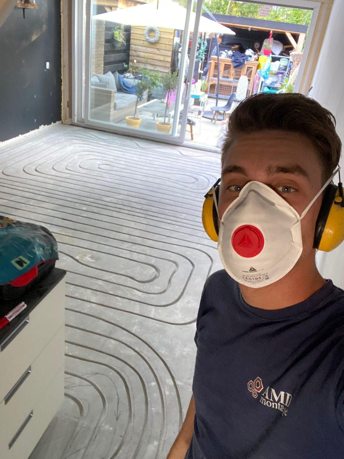 Anthony Loorbach met stofmasker en gehoorbescherming bij een ingefreesde vloer